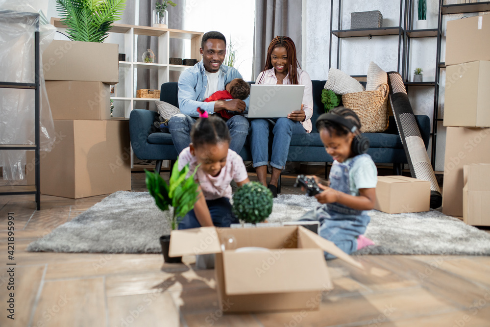 Afro american parents and three kids enjoying moving day Afro american parents and three kids enjoying moving day