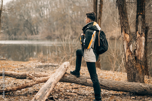 in the woods with a foot on a log