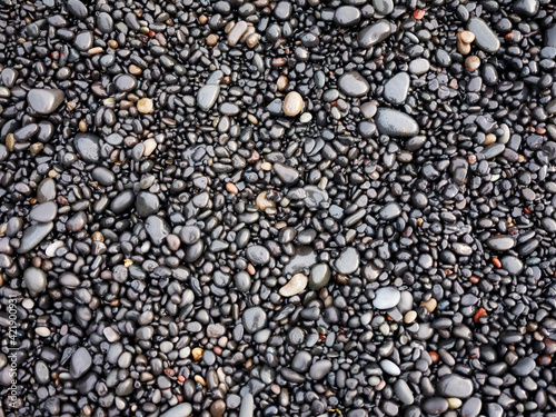 Gray pebbles as a background in the Iceland sea shore. Abstract composition. Design image.