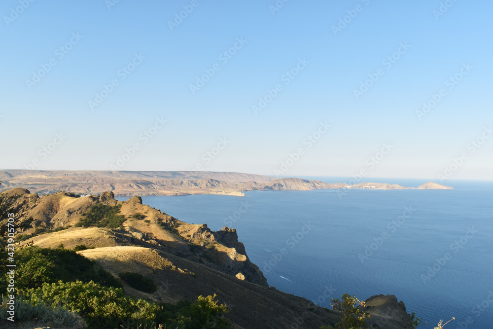 beautiful summer landscape with a bay and yellow rocks against the sky