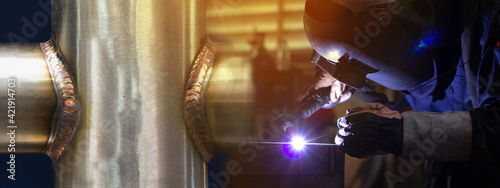 Welder is welding the steel in the factory.