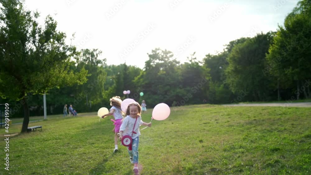 Group of happy children playfully running with multicolored balloons Group of happy children playfully running with multicolored balloons