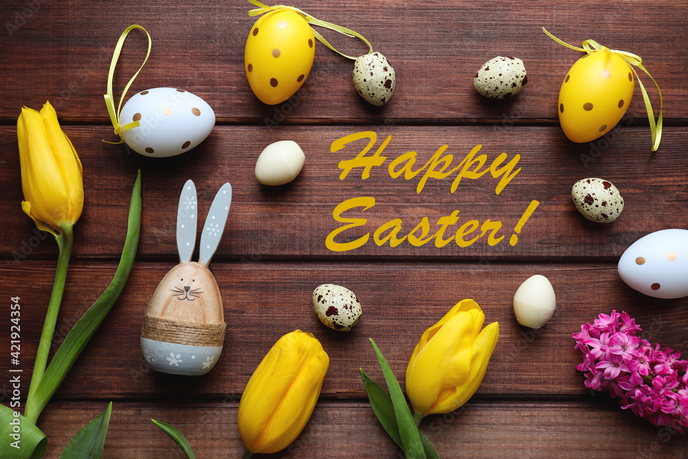Easter card with yellow tulips, wooden bunny, decorative colored and chocolate eggs, and the inscription Happy Easter on a rustic wooden background. Top view, flat lay Easter card with yellow tulips, wooden bunny, decorative colored and chocolate eggs, and the inscription Happy Easter on a rustic wooden background. Top view, flat lay