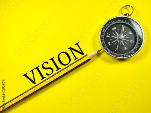 Business concept.Text VISION with pencil and compass on yellow background.