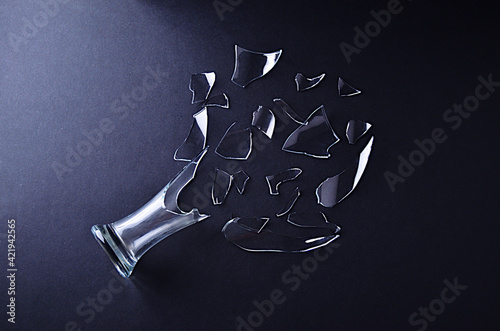 Broken glass vase with decomposed shards of glass on a black background. High quality photo