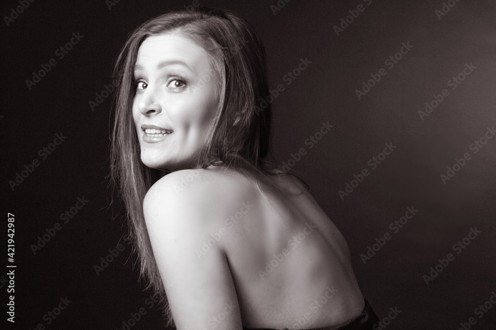black and white portrait of an adult woman in a studio on black background. black and white portrait of an adult woman in a studio on black background.