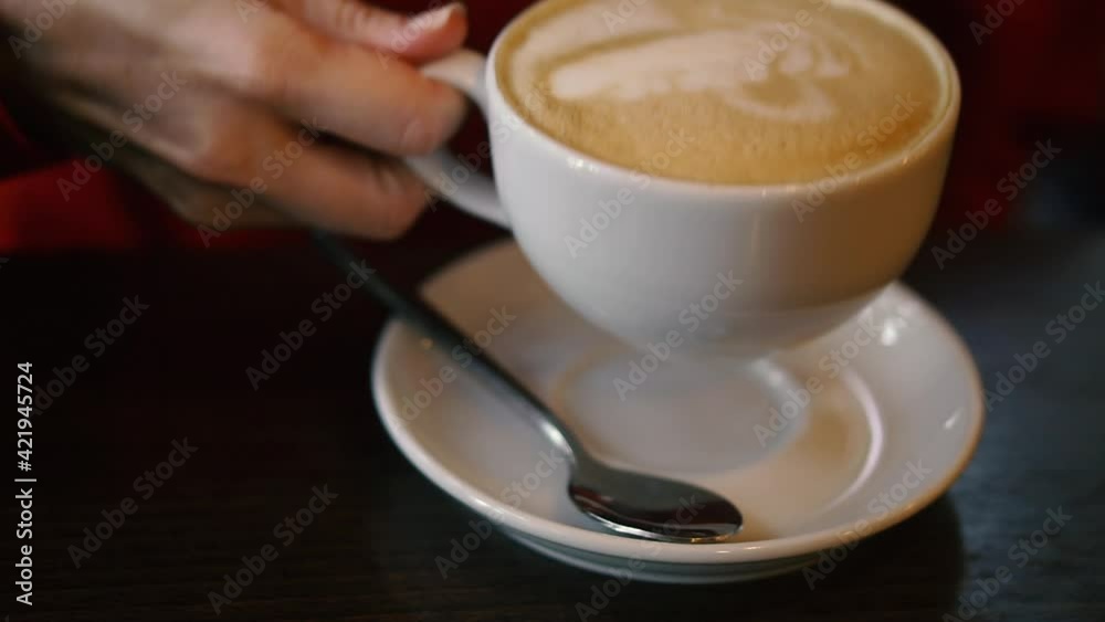 Cappuccino. A woman's hand takes a cup of cappuccino. Cappuccino. A woman's hand takes a cup of cappuccino.