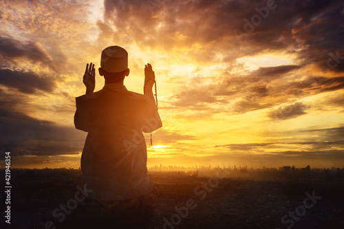 Fototapeta Silhouette of a devout man pray to the Allah on hill