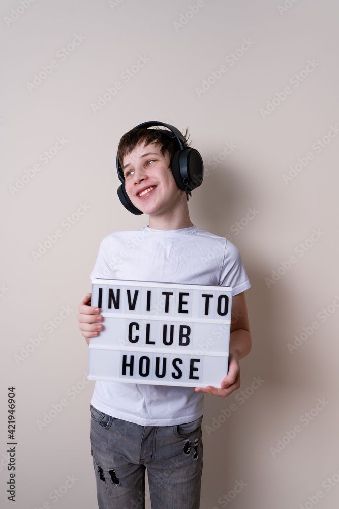 Happy teenager school boy holding a letter board with the words about inviting to social media Happy teenager school boy holding a letter board with the words about inviting to social media