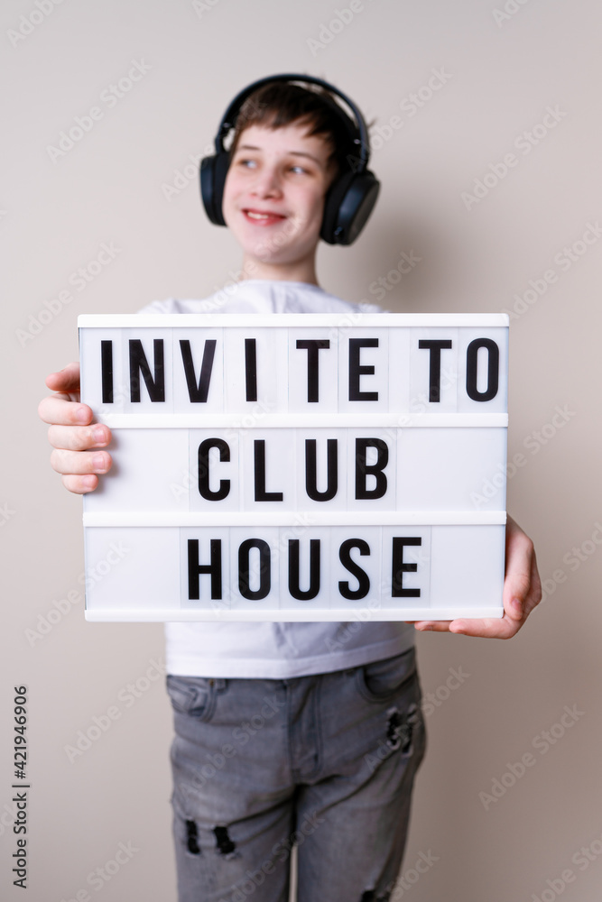 Happy teenager school boy holding a letter board with the words about inviting to social media Happy teenager school boy holding a letter board with the words about inviting to social media
