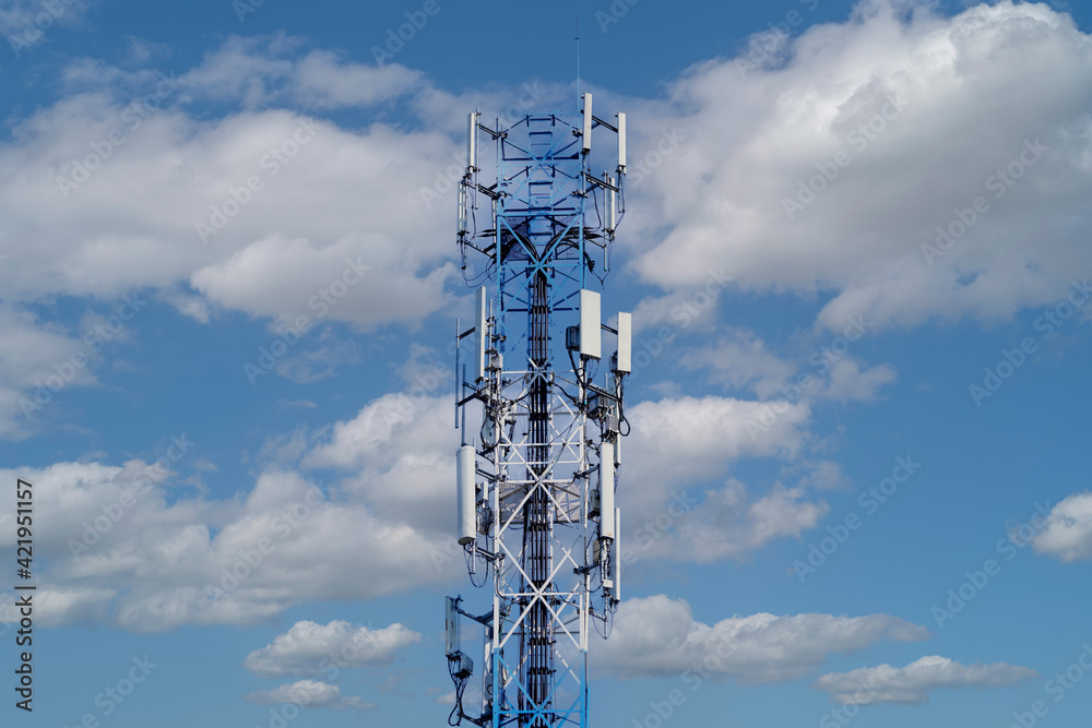 Telecommunication tower of 4G and 5G cellular. Macro Base Station. 5G radio network telecommunication equipment with radio modules and smart antennas mounted on a metal against cloulds sky background. Telecommunication tower of 4G and 5G cellular. Macro Base Station. 5G radio network telecommunication equipment with radio modules and smart antennas mounted on a metal against cloulds sky background.