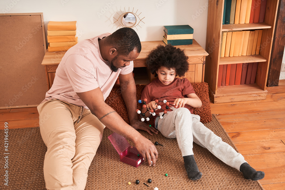 Boy having fun while spending time at home with his father