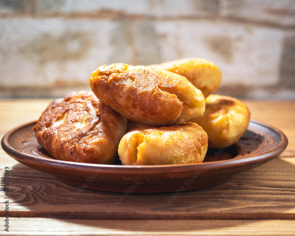 Fried pies on a clay plate close-up for a breakfast Fried pies on a clay plate close-up for a breakfast