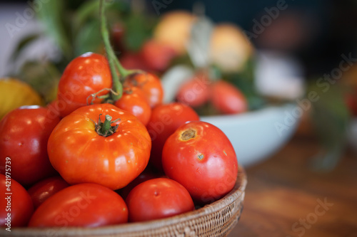fresh tomatoes in basket on wooden table