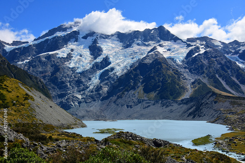 Fototapeta Naklejka Na Ścianę i Meble -  spectacular view of rugged mountain peaks and a glacial lake along the hooker valley track  on a sunny summer day, near mount cook village, on the south island of new zealand