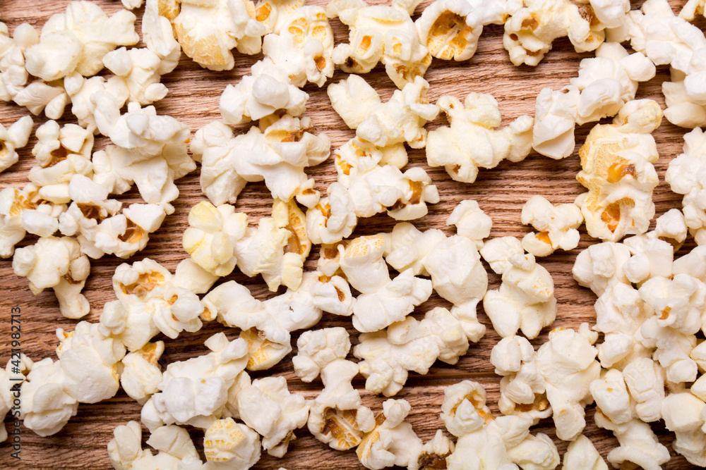 Heap of delicious popcorn isolated on wooden background. popcorn close-up
