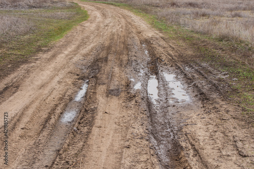 Country road. Autumn dirt road. Puddle and mud with deep ruts.