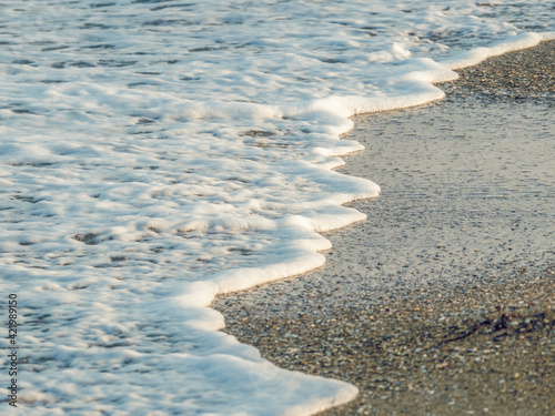 Sea water foam on the sandy beach