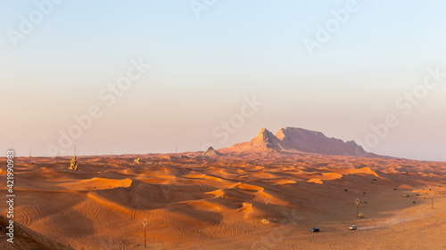 Panorama of sunset over Fossil Rock mountain ridge and golden desert dunes  Sharjah  United Arab Emirates.