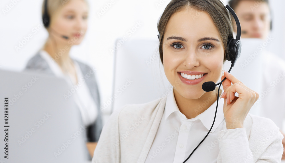 Call center. Group of diverse operators at work. Beautiful woman in headset communicating with customers of telemarketing service. Business concept Call center. Group of diverse operators at work. Beautiful woman in headset communicating with customers of telemarketing service. Business concept