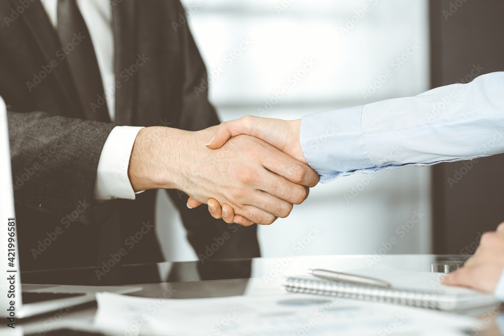 Unknown business man and woman are shaking hands finishing contract signing, close-up. Business and handshake concept Unknown business man and woman are shaking hands finishing contract signing, close-up. Business and handshake concept