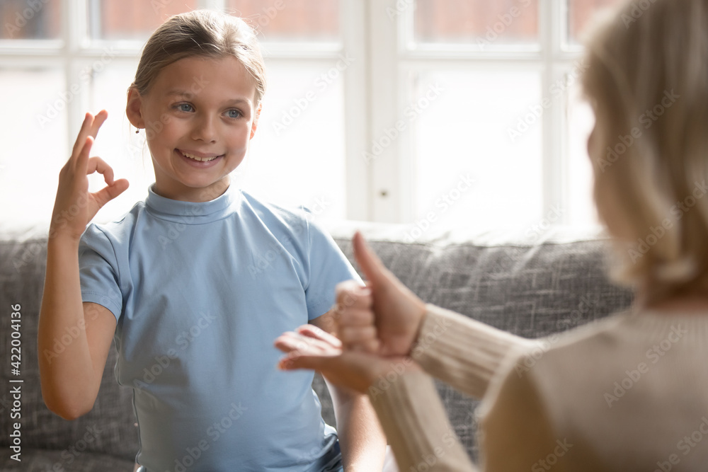 Happy girl learning sign language with speech therapist Happy girl learning sign language with speech therapist