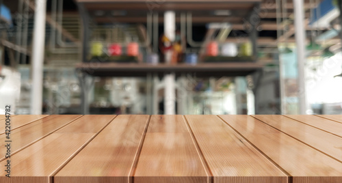 Empty wooden table top with lights bokeh on blur restaurant background.