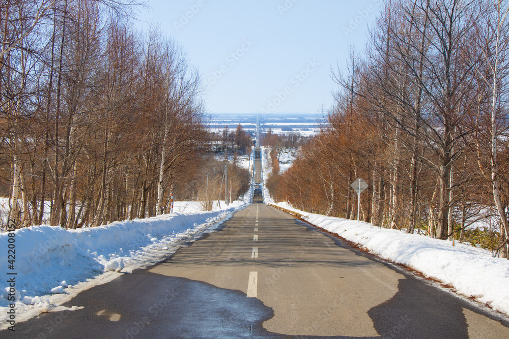 Straight path with snowy scenery in Shari, Shiretoko, Hokkaido, Japan Straight path with snowy scenery in Shari, Shiretoko, Hokkaido, Japan