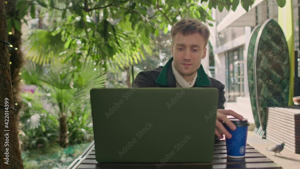 Close up of young freelancer typing on notebook in the cafe writing notes. Close up of young freelancer typing on notebook in the cafe writing notes.
