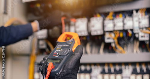 Konstfotografi Electrician engineer work tester measuring voltage and current of power electric line in electical cabinet control