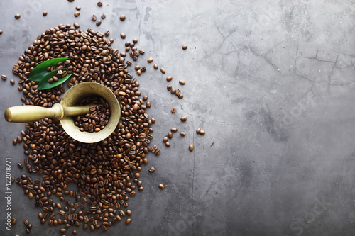 Bag of coffee. Coffee beans roasted on the table. Coffee beans with green leaves for cooking.