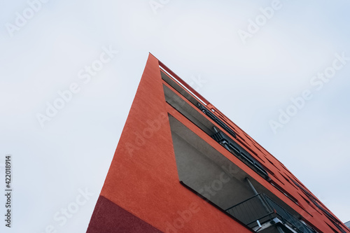 A fragment of a modern building with a geometric shape against a blue sky.Urban abstract futuristic architecture in the style of minimalism creates a geometric stylish pattern.Vertical orientation