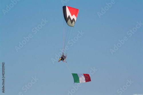 Flying paraglyder with italian flag