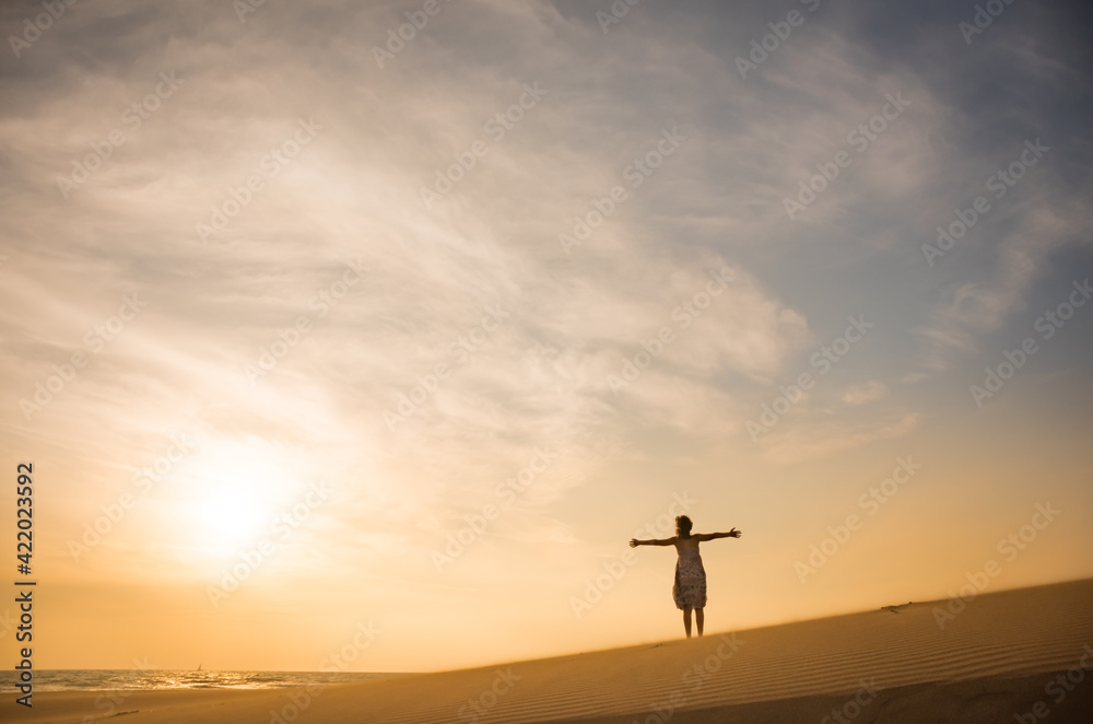 Freedom and happiness. Along young woman on sand enjoying sun, nature