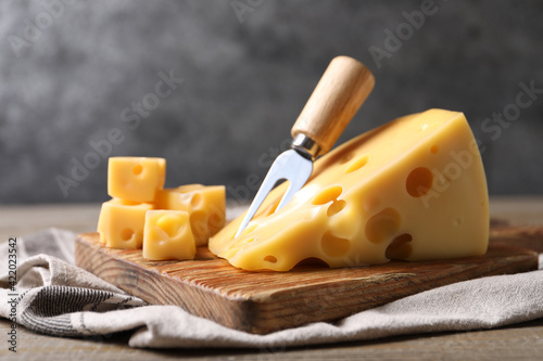 Tasty fresh cheese with fork on wooden table, closeup photo