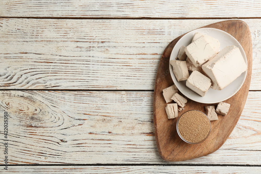 Compressed and granulated yeast on white wooden table, top view. Space for text Compressed and granulated yeast on white wooden table, top view. Space for text