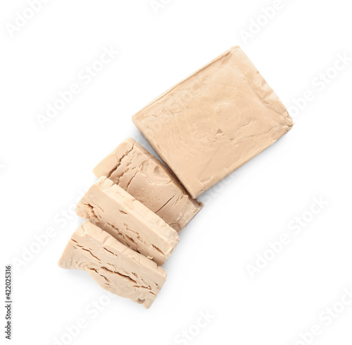Pieces of compressed yeast on white background, top view