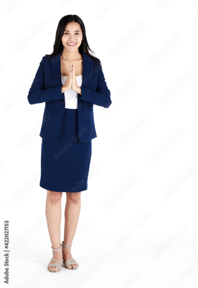 Portrait studio shot of a young friendly face and beautiful Asian woman in dark blue office business suit standing with friendly smile face pose hands for original Thai style greeting, Sawasdee Portrait studio shot of a young friendly face and beautiful Asian woman in dark blue office business suit standing with friendly smile face pose hands for original Thai style greeting, Sawasdee