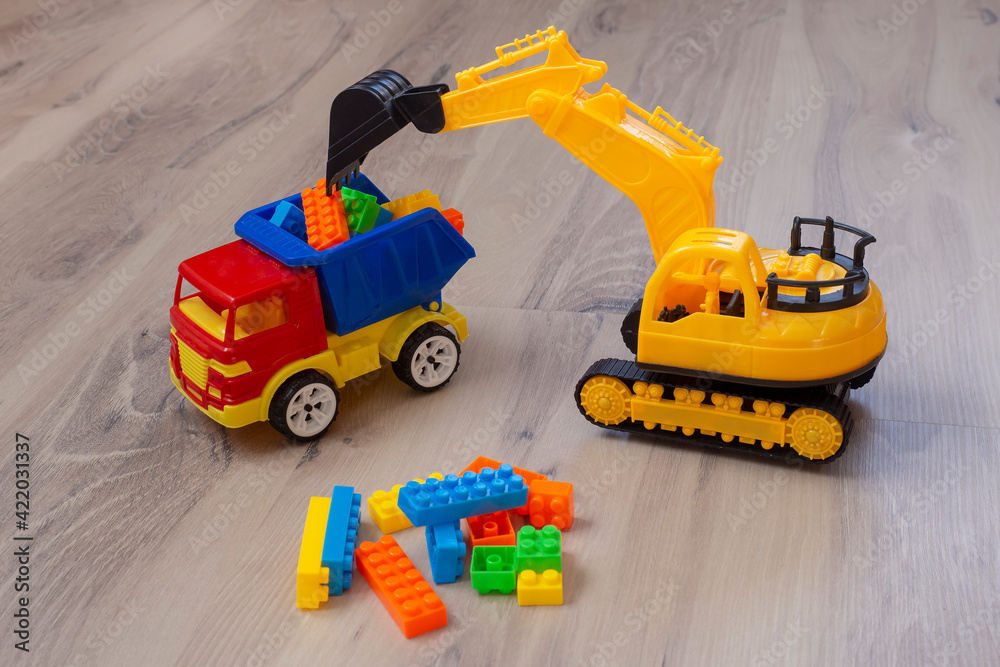 Plastic toy truck and excavator. Multicolored children's toys. Game.