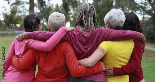 Multiracial women hugging each other - Back view of multi generational people together outdoor at park 