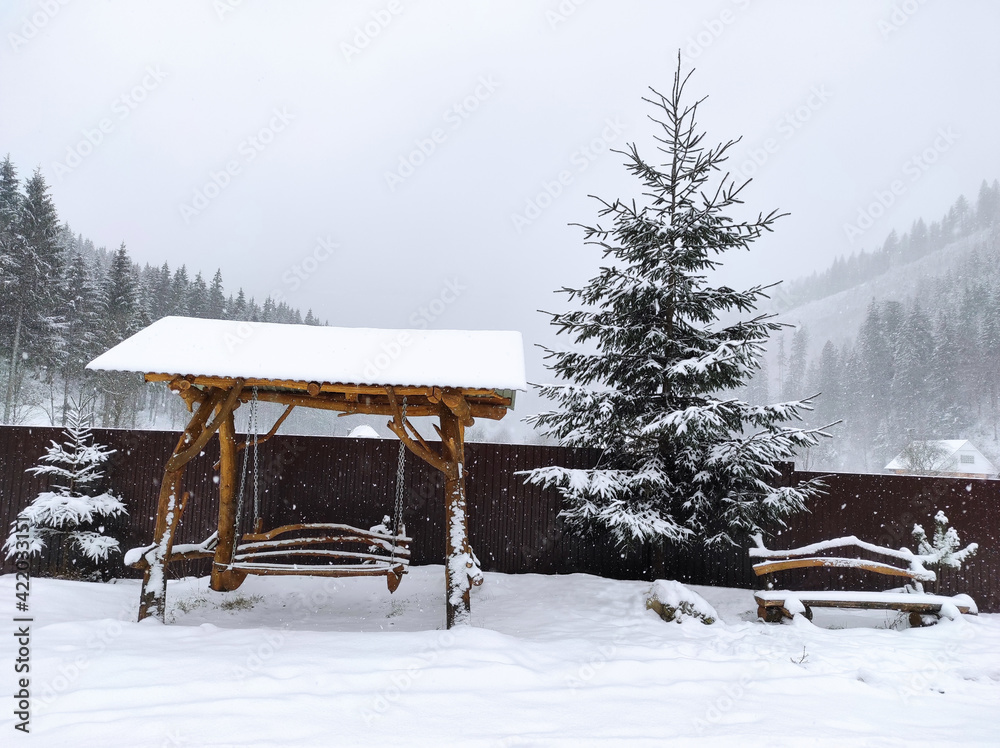 wooden swing in the snow with a Christmas tree wooden swing in the snow with a Christmas tree