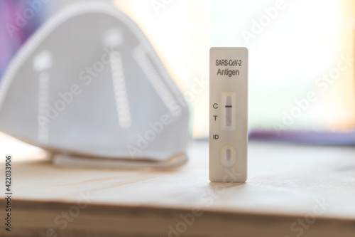 Express corona test at home: Close up of a negative covid antigen test, ffp2 mask in background