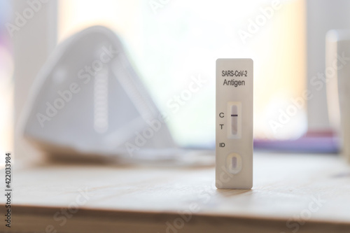Express corona test at home: Close up of a negative covid antigen test, ffp2 mask in background photo