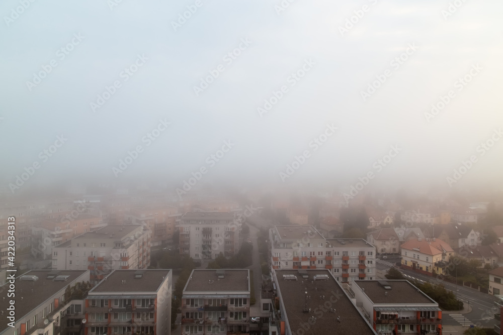Prague's residential district in foggy early morning. Building's silhouettes through morning fog. Aerial photography. Misty cityscape from above.