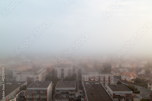 Obraz na płótnie Prague's residential district in foggy early morning. Building's silhouettes through morning fog. Aerial photography. Misty cityscape from above. w salonie