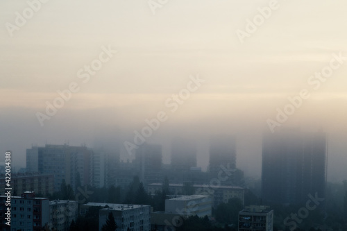 Prague's residential district in foggy early morning. Building's silhouettes through morning fog. Aerial photography. Misty cityscape from above.