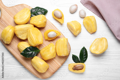 Fototapeta Naklejka Na Ścianę i Meble -  Delicious exotic jackfruit bulbs on white wooden table, flat lay