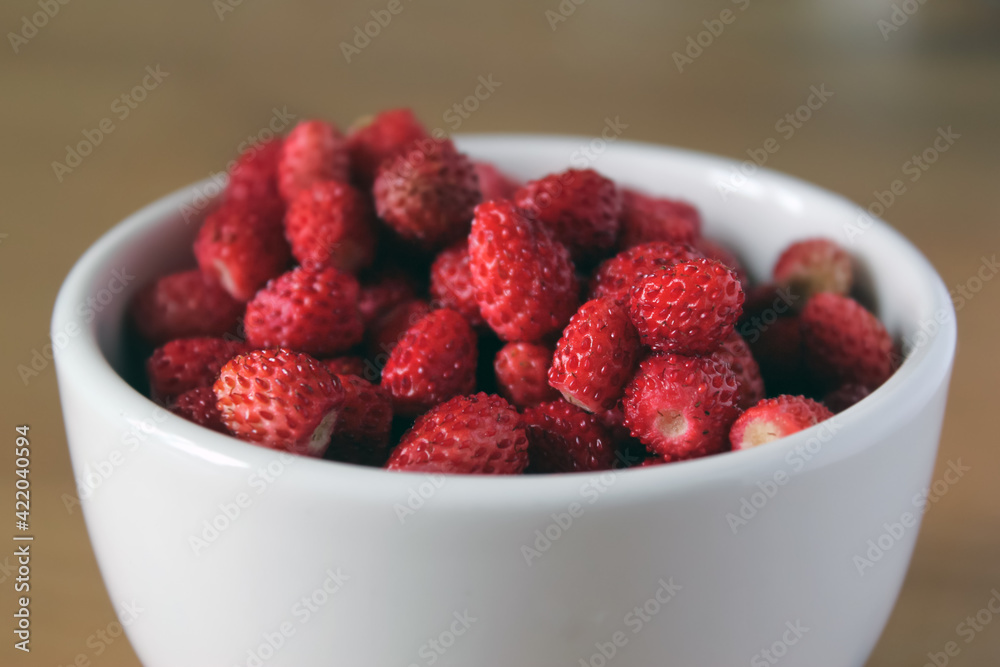 Red berries in a bowl on the table.