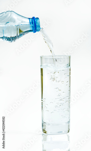Water bottle pour water to glass on white background 