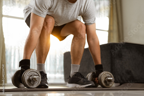 Sport man prepare doing dumbbell exercise workout in home.